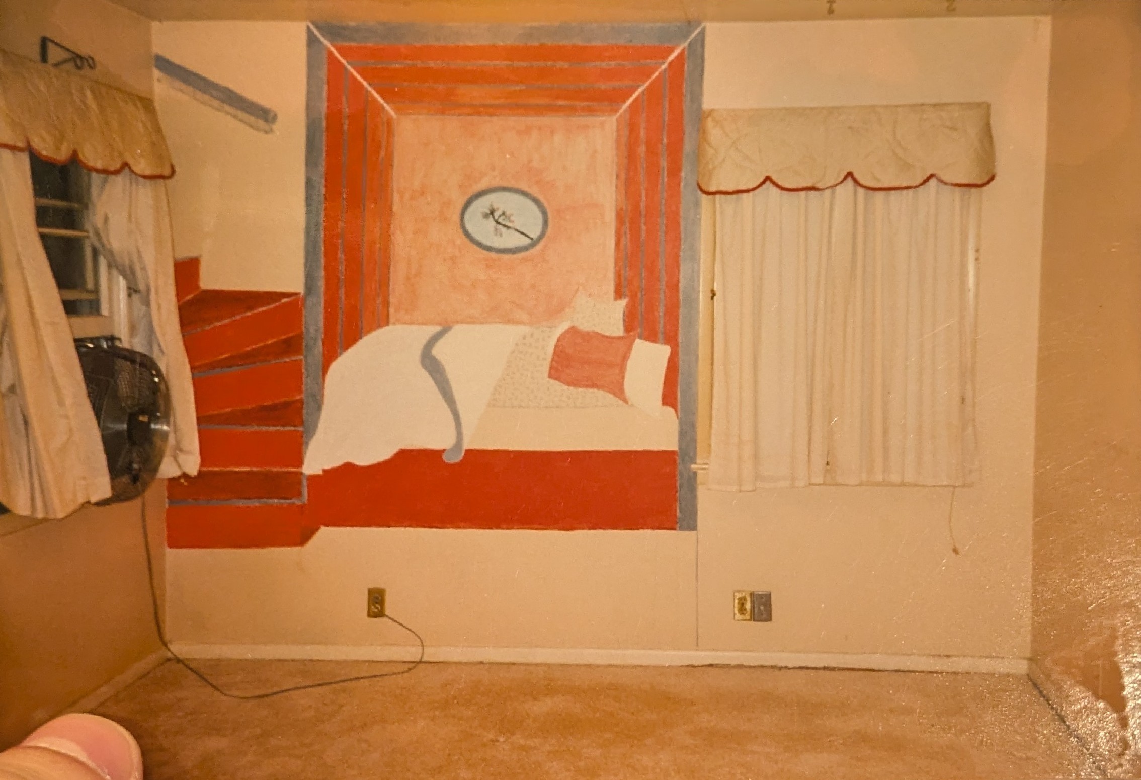 Photo of a wall mural featuring an unmade bed in a red room, with a circular painting of a blooming tree branch above it and a red staircase to its left, turning into nowhere. Extended notes: this was in a bedroom of my parents' house, but they covered it shortly after they bought the house in 1995. That bedroom later became my childhood bedroom, and the mural is still hidden beneath its paint. My thumb is visible in the corner because I was holding the print when I took the picture of it.